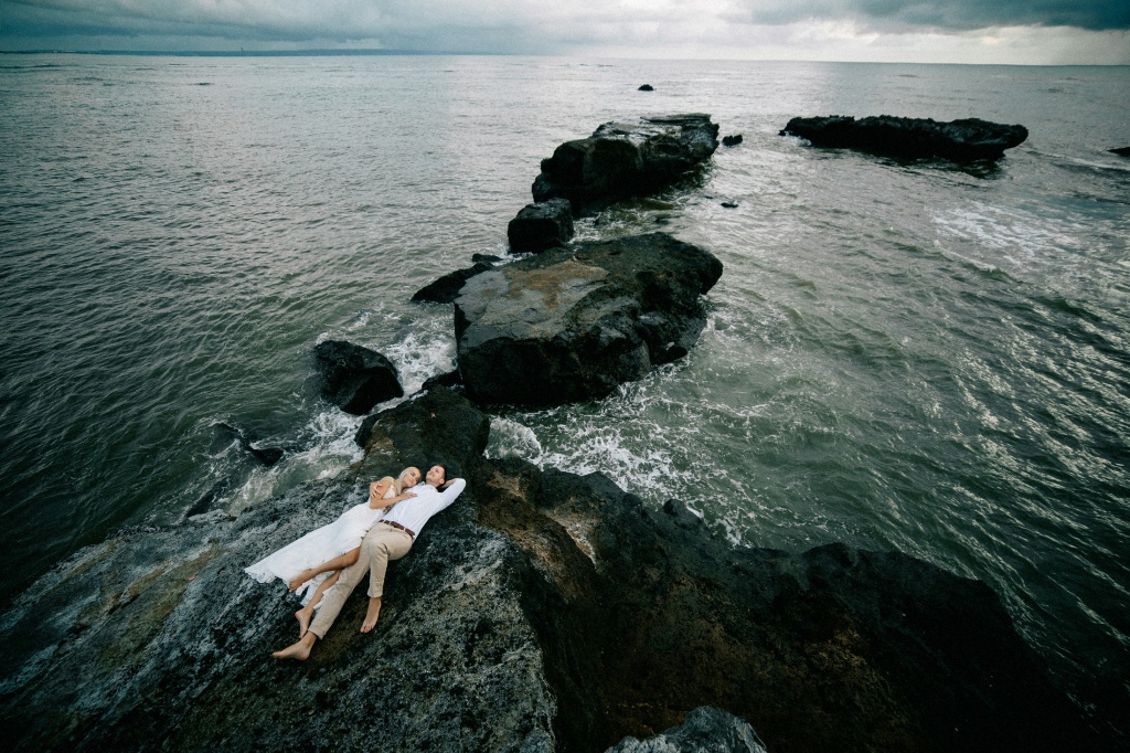 Свадебная фотосессия на скале возле черного пляжа